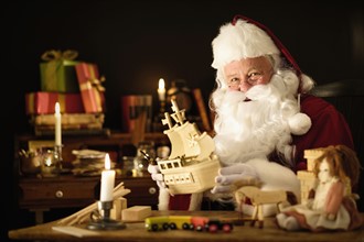 Santa Claus making wooden toy.