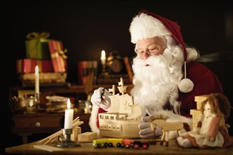 Santa Claus making wooden toy.