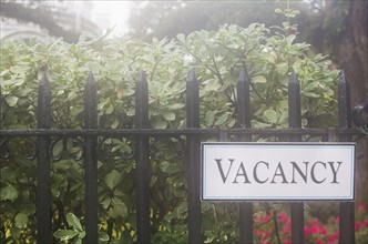 Vacancy sign on hotel's fence