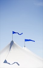 White tents with blue flags at county fair