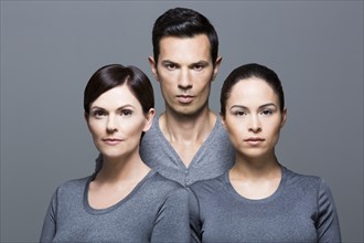 Man and two women wearing grey tops