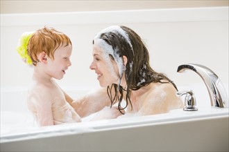 Mother and son (2-3) having bubble bath
