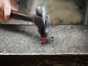 Close up of hand of female blacksmith with hammer