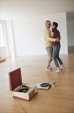 Couple dancing in new apartment.