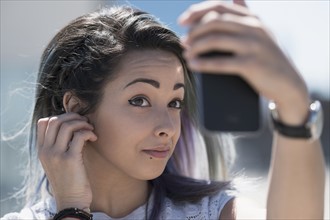 Young woman holding mobile phone.