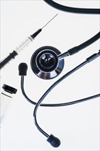 Stethoscope, syringe and test tube on white background.