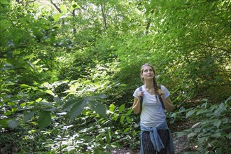 Young woman standing in woodlands.