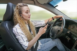 Woman using mobile phone during driving car.