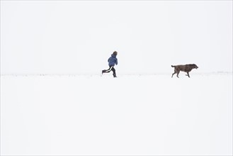 Boy (6-7) running with dog