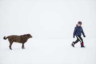 Boy (6-7) walking with dog