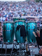 Green drums on stage with audience in background