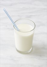 Glass of milk with drinking straw