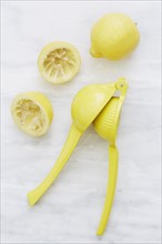 Overhead view of lemons and yellow juicer