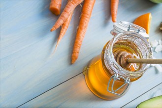 High angle view of jar of honey and carrots