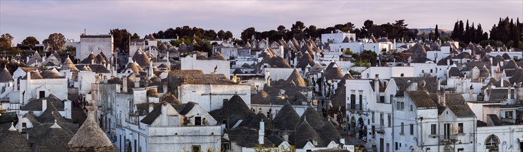 Italy, Apulia, Alberobello, Old town panorama of old trulli houses at sunset