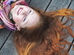 Portrait of smiling redhead lying down