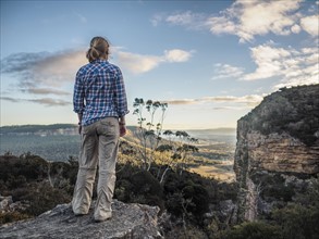 Australia, New South Wales, Blue Mountains, Blackheath, Megalong Valley, Mature woman standing on rock and looking at valley below