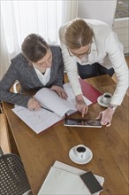 Businesswomen working with tablet and documents