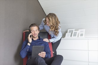 Mid-adult couple using tablet and smart phone