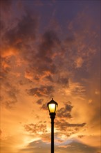 Dramatic sunset sky with lamp post in foreground.