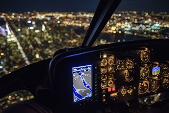 USA, New York, New York City, Illuminated skyline at night seen from helicopter cockpit.