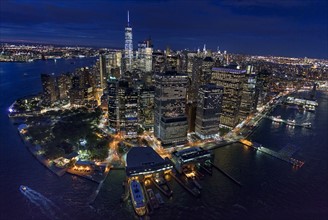 USA, New York, New York City, Manhattan, Aerial view of illuminated skyline with harbor at night.