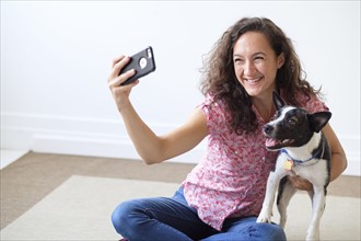 Young woman taking selfie with her dog.