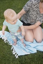Mother with son (6-11 months) playing on grass