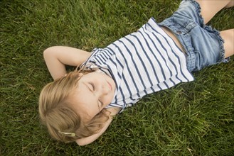 Girl (2-3) lying on grass