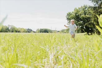 USA, Pennsylvania, Washington Crossing, Boy (4-5) running in green field