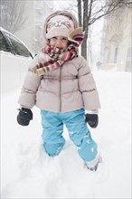 Girl (2-3) in winter clothing standing on snow