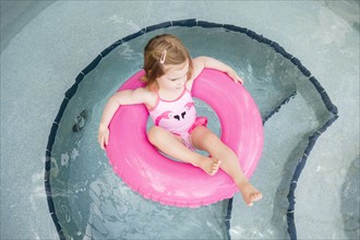 Girl (2-3) on inflatable ring in pool