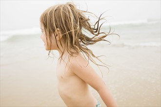 USA, New York, Monatuk, Girl (2-3) running on beach by ocean
