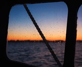 Sea at sunset seen through boat window