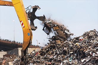 Crane and heap of scrap in junkyard