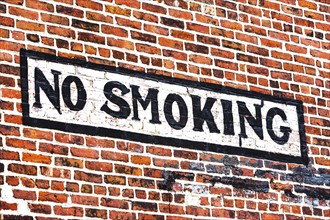 No smoking sign on red brick wall