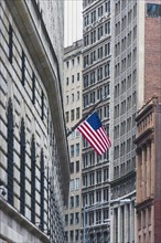 USA, New York State, New York City, Manhattan, Wall Street, American flag among skyscrapers