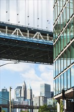 USA, New York State, New York City, City panorama with part of Brooklyn Bridge and skyscraper's facade in foreground