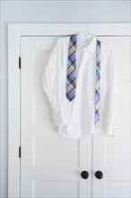 Shirt and tie hang on closet door
