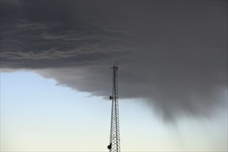 Storm clouds gathering above communications tower