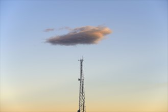 Cloud over communication tower at dusk