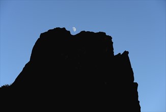USA, Colorado, Moon over silhouette of rocks in Roxborough State Park
