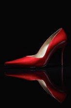 Red shoe against black background