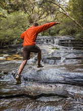 Australia, New South Wales, Katoomba, Man running on rocks of Leura Cascade