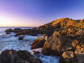 Australia, New South Wales, Port Macquarie, Lighthouse on rocky coat at sunrise