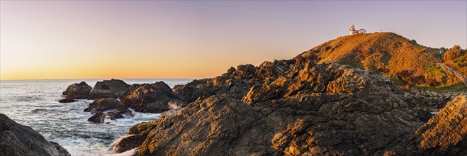 Australia, New South Wales, Port Macquarie, Lighthouse on rocky coat at sunrise