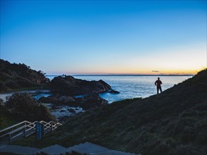 Australia, New South Wales, Port Macquarie, Silhouette of man looking at sea at sunrise