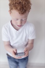 Boy (8-9) looking at smart phone