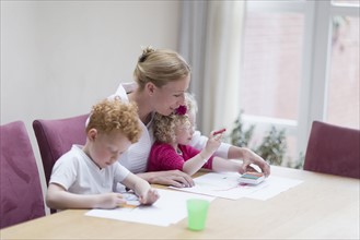 Mother drawing with son (8-9) and daughter (4-5)