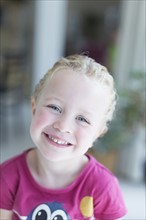 Portrait of blonde girl (4-5) looking at camera and smiling